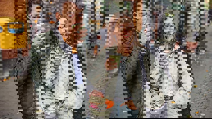 två unga personer dricker ur pappersmuggar